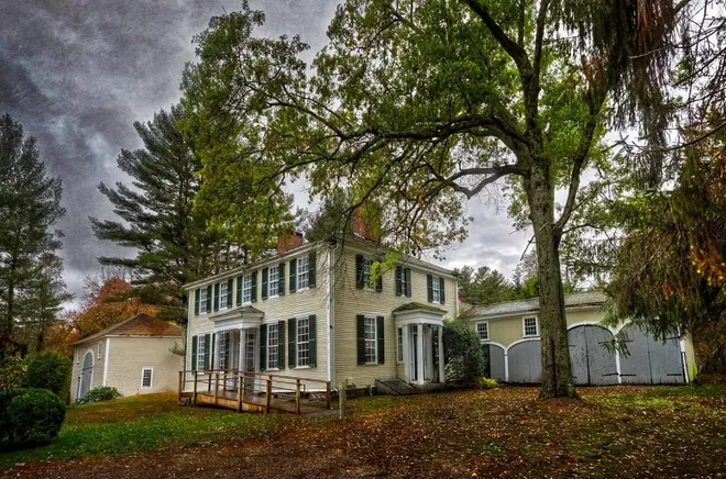 The Oliver House, a pale yellow colonial house with dark shutters, portico, accessibility ramp, and carriage wing at 445 Plymouth Street